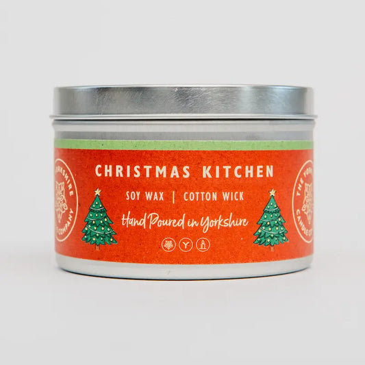 Candle tin labeled 'Christmas Kitchen' with red label and silver lid on a light gray background