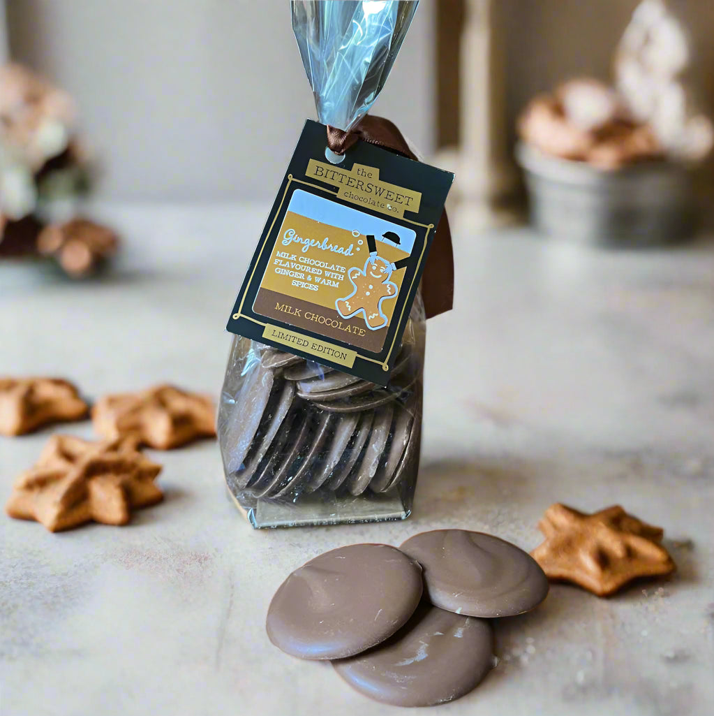 Packaged chocolate discs with a visible brand label on a wooden surface