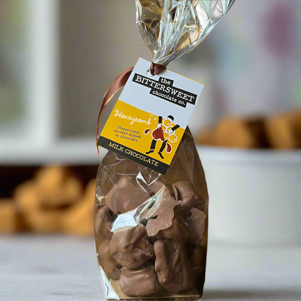 Bag of milk chocolate candies with a 'Bittersweet Chocolates' label on a wooden surface.
