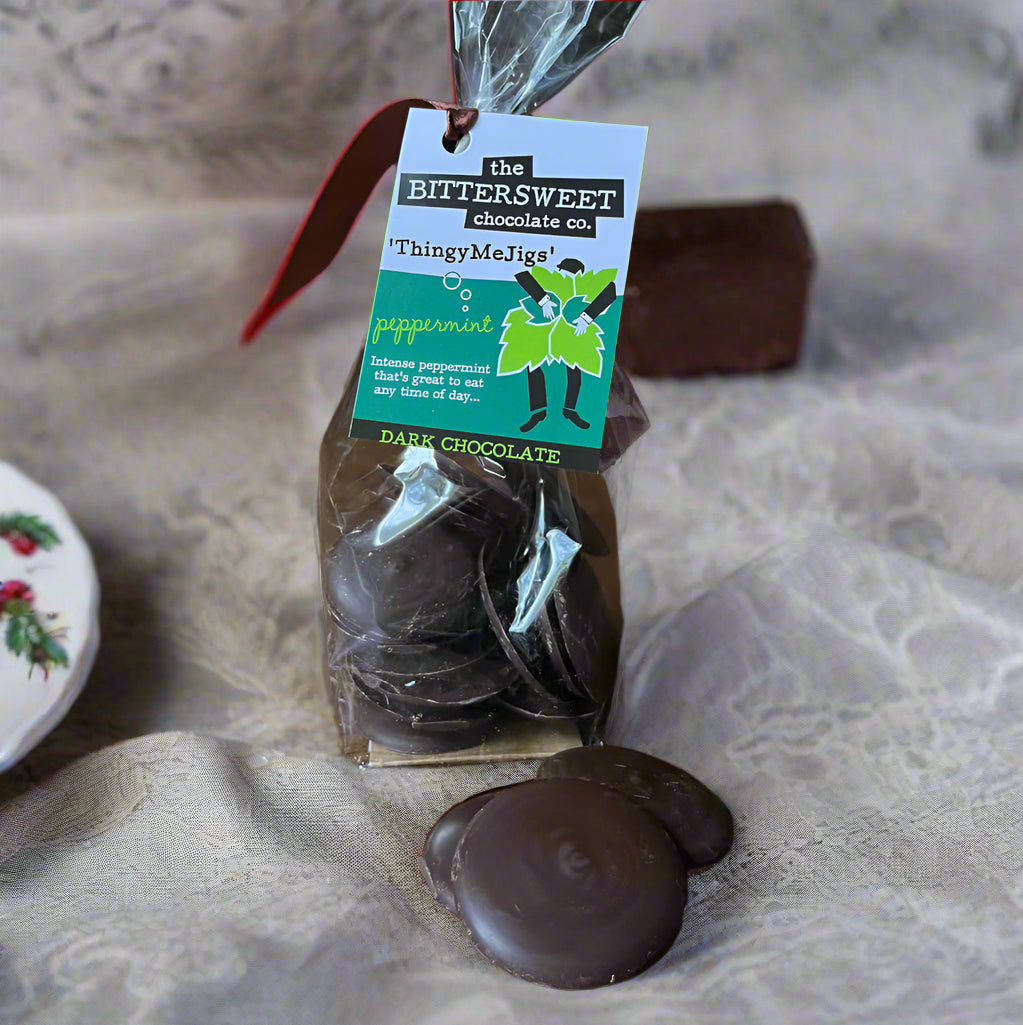 Packaged dark chocolate peppermint buttons with a visible brand tag on a wooden surface.