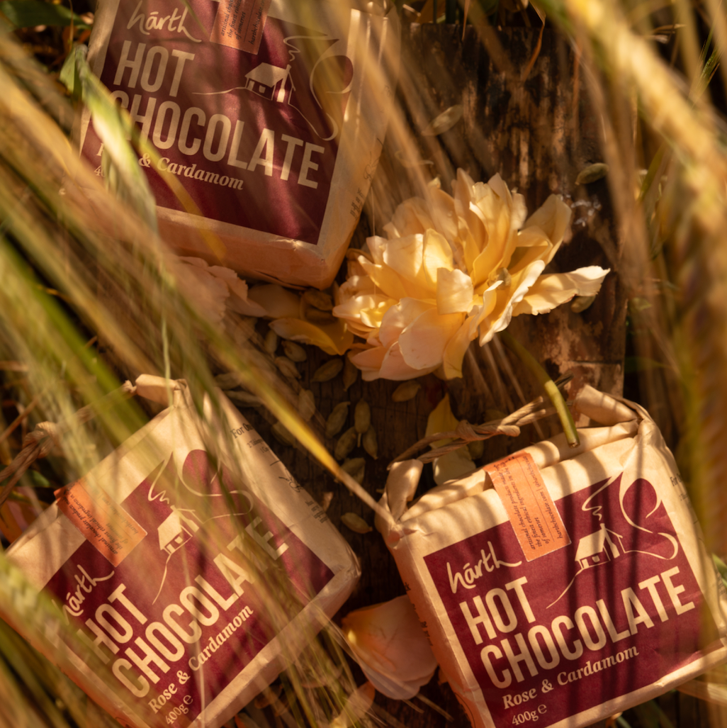 Hot chocolate packets with a decorative flower arrangement on a dark background