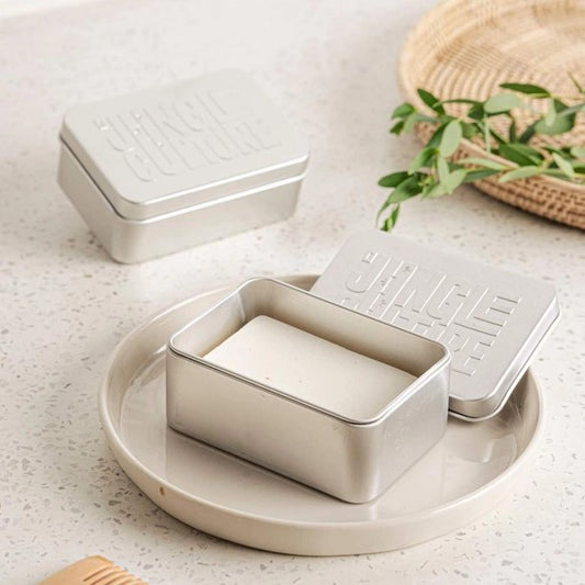 Rectangular metal soap dish with embossed design on a light surface.