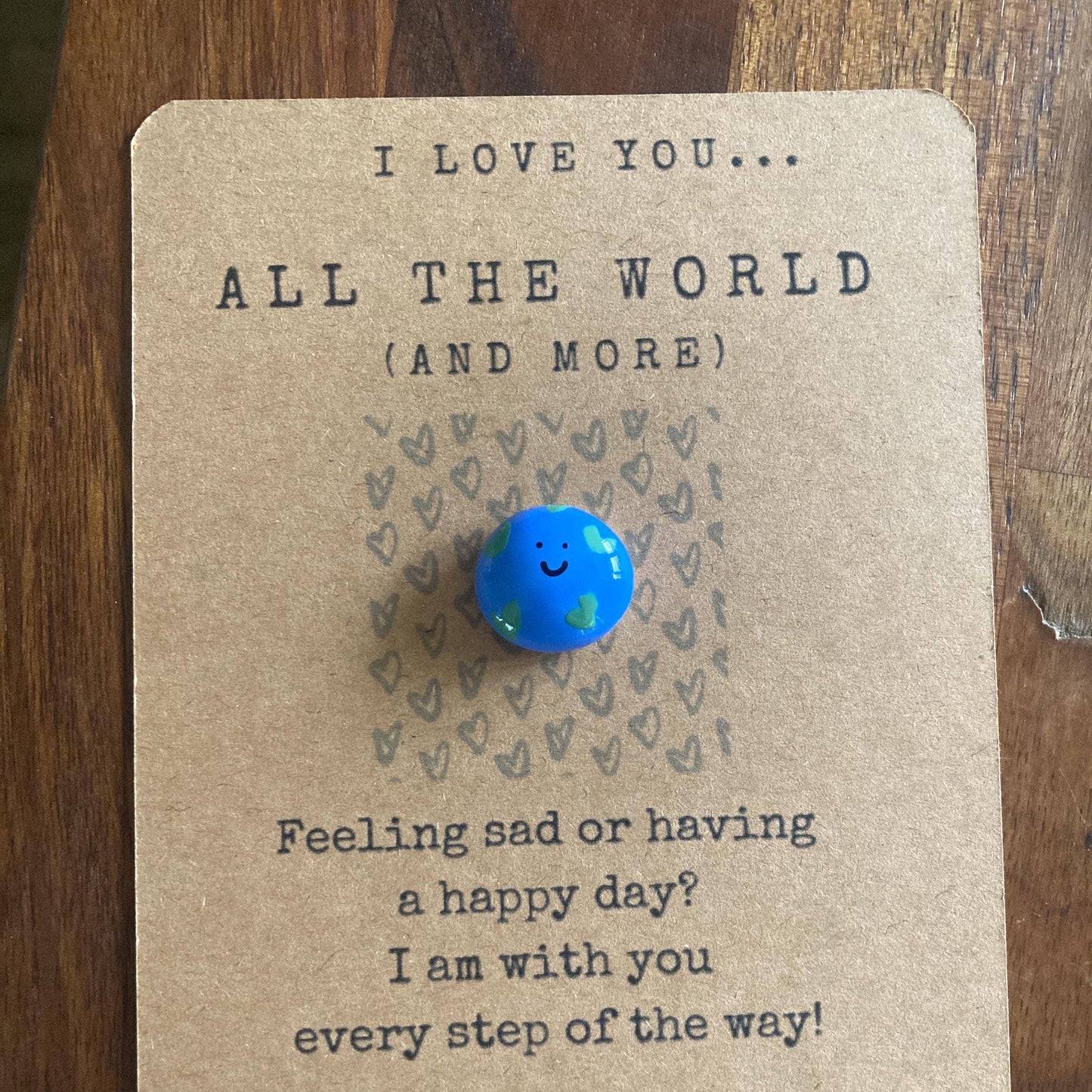 Blue round charm on a card with text on a wooden surface