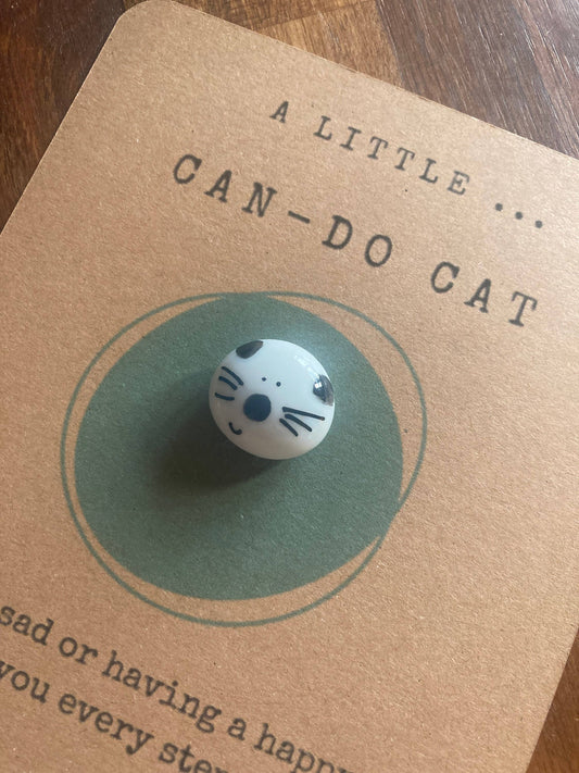 Notecard with a cat-themed token on a wooden surface