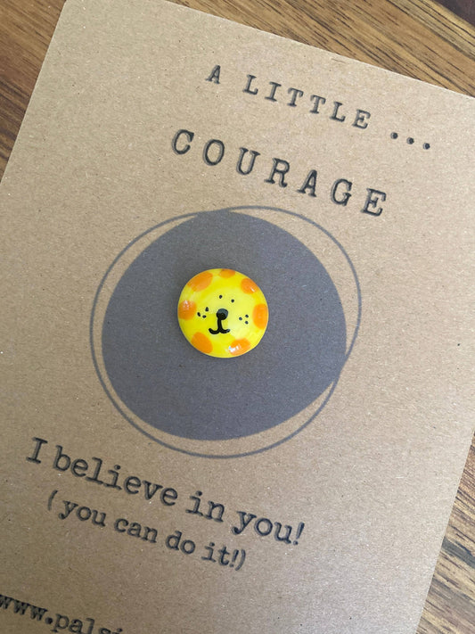 Charm with a lion design on a 'A Little Courage' card