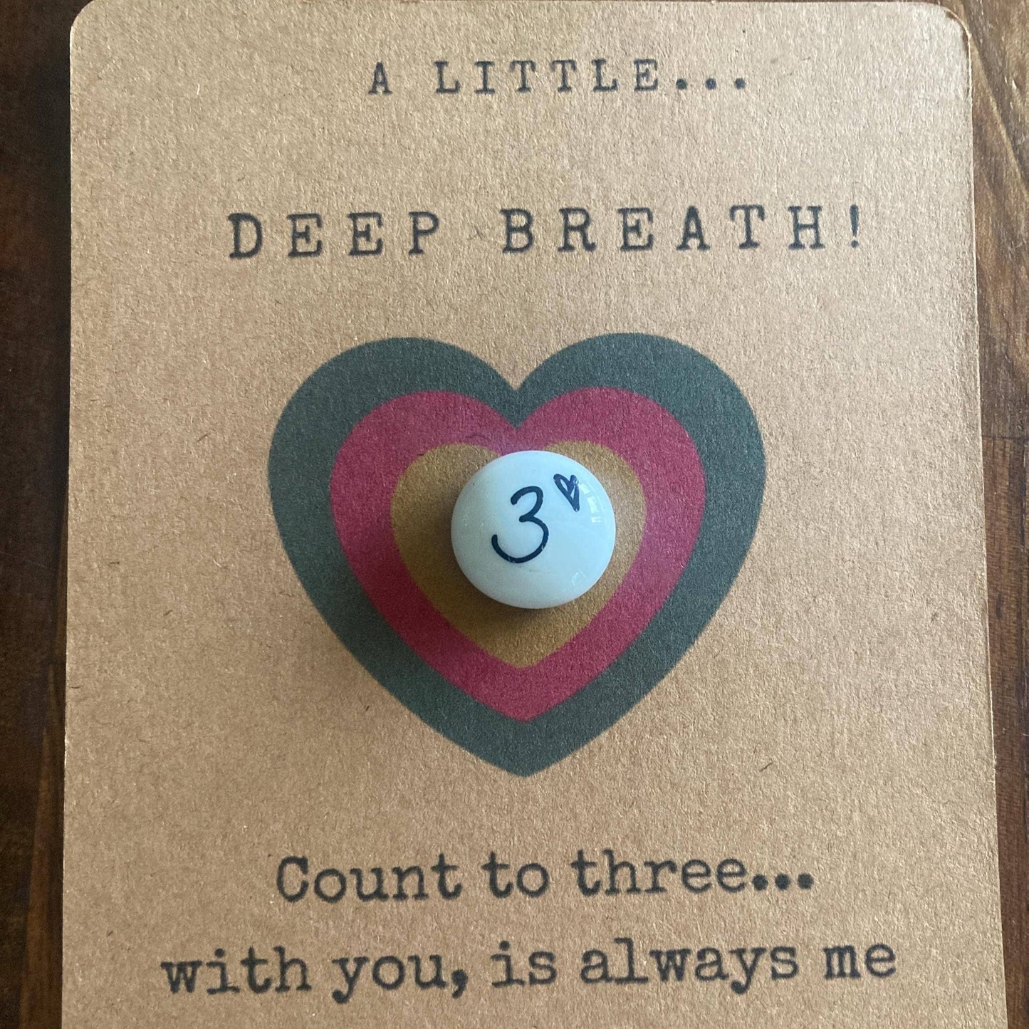Card with a heart design and a small pebble, featuring text about taking deep breaths and connecting with someone.