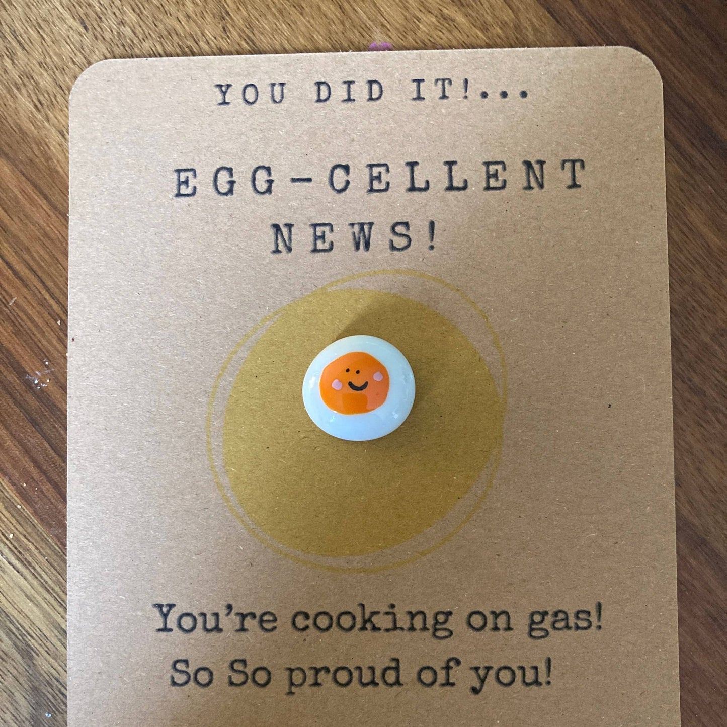 Card with an egg illustration and text on a wooden surface