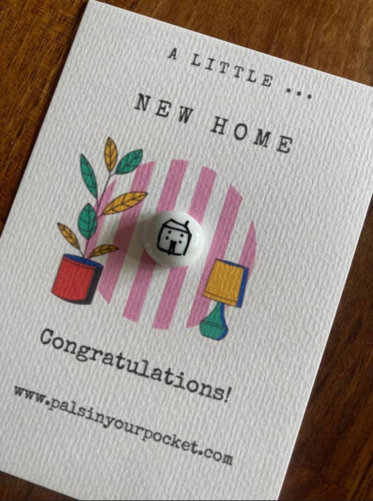 Greeting card with a small round object and illustrations on a wooden surface