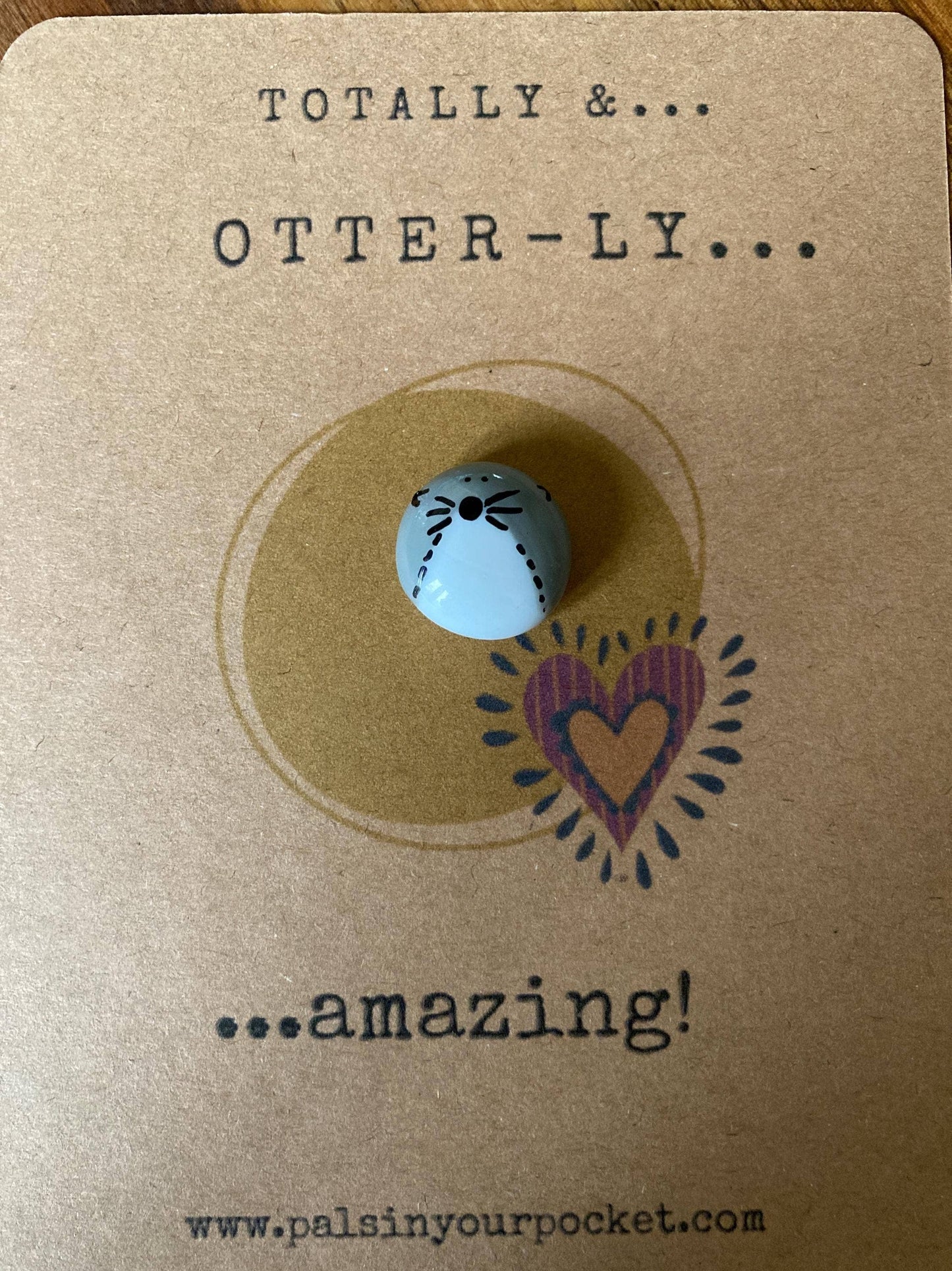 Pebble with a heart design on a brown card with text 'TOTALLY &... OTTER-LY... ...amazing!'