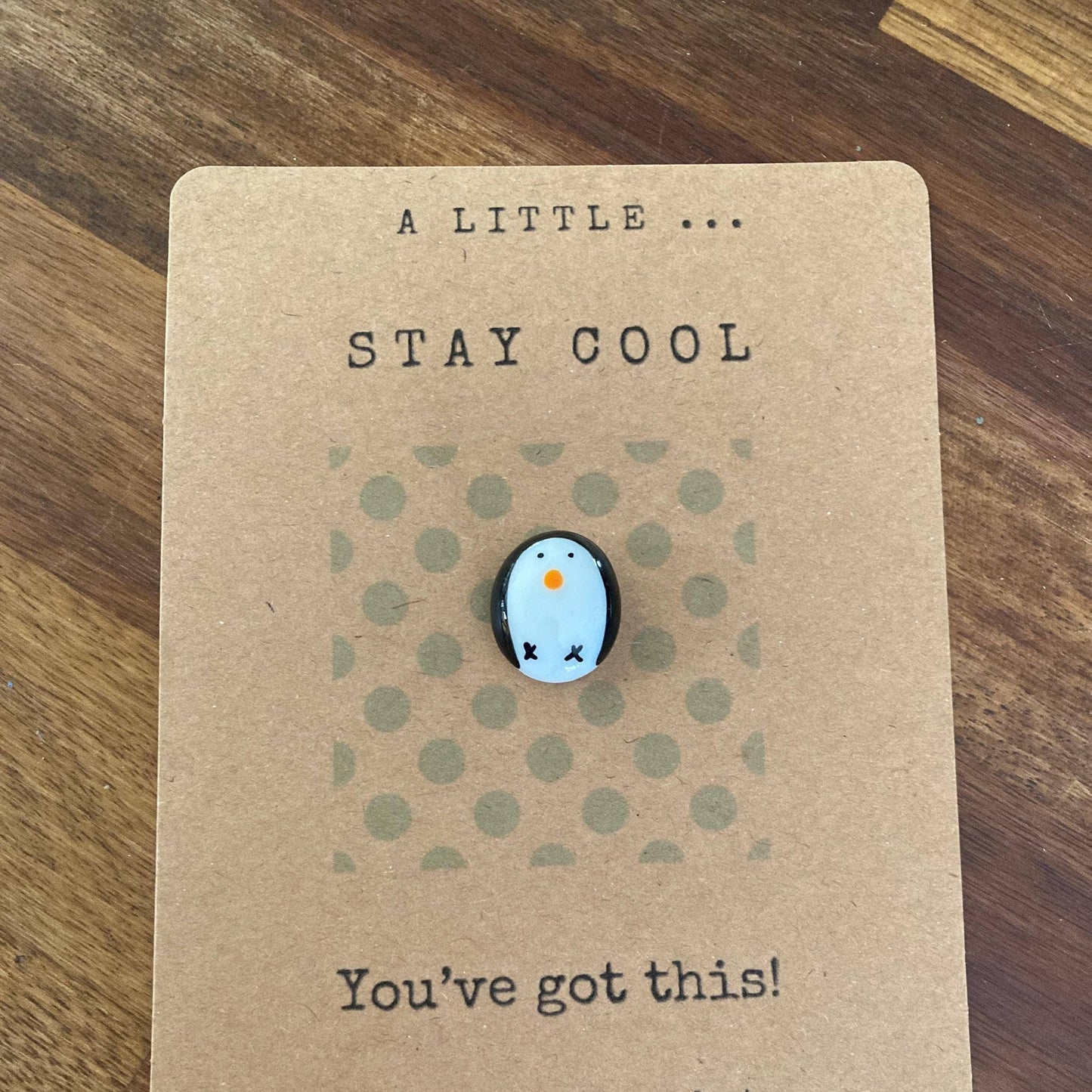 Pebble on a card with 'Stay Cool' text on a wooden surface