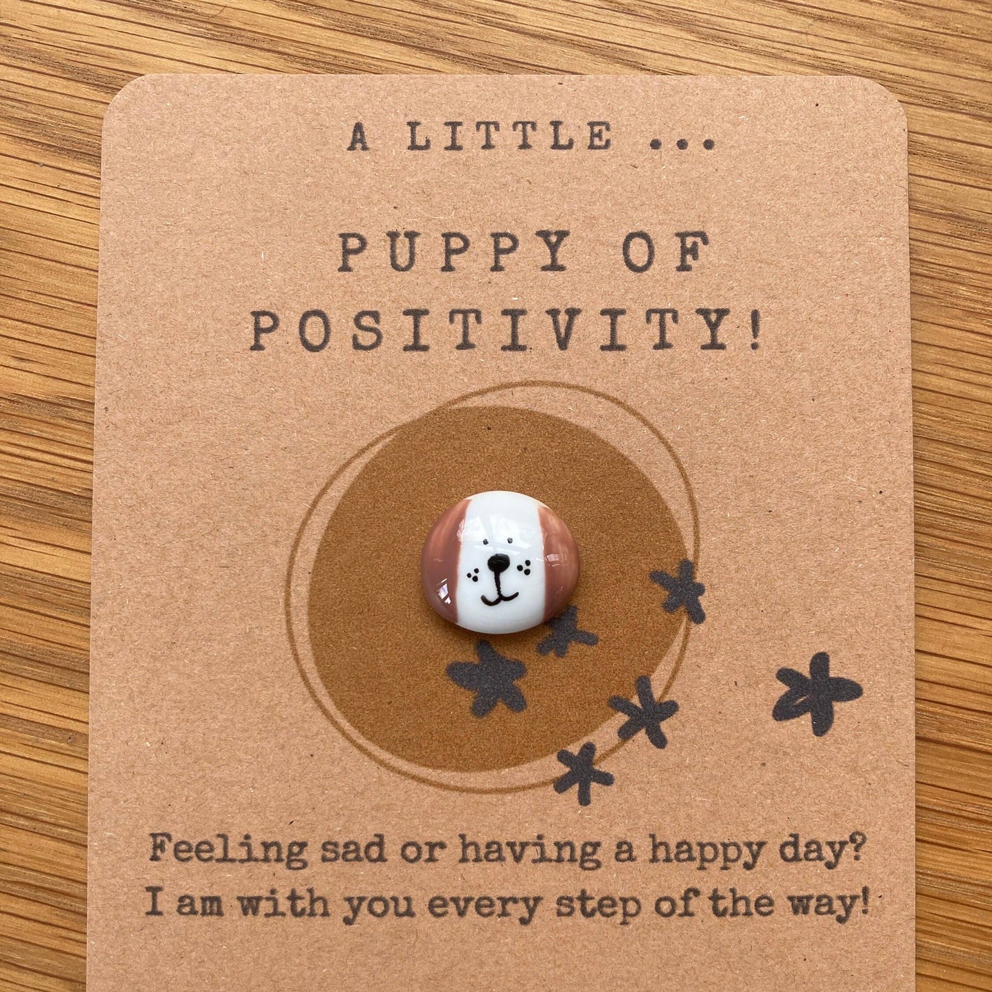 Card with a small round token featuring a dog face design on a brown background.