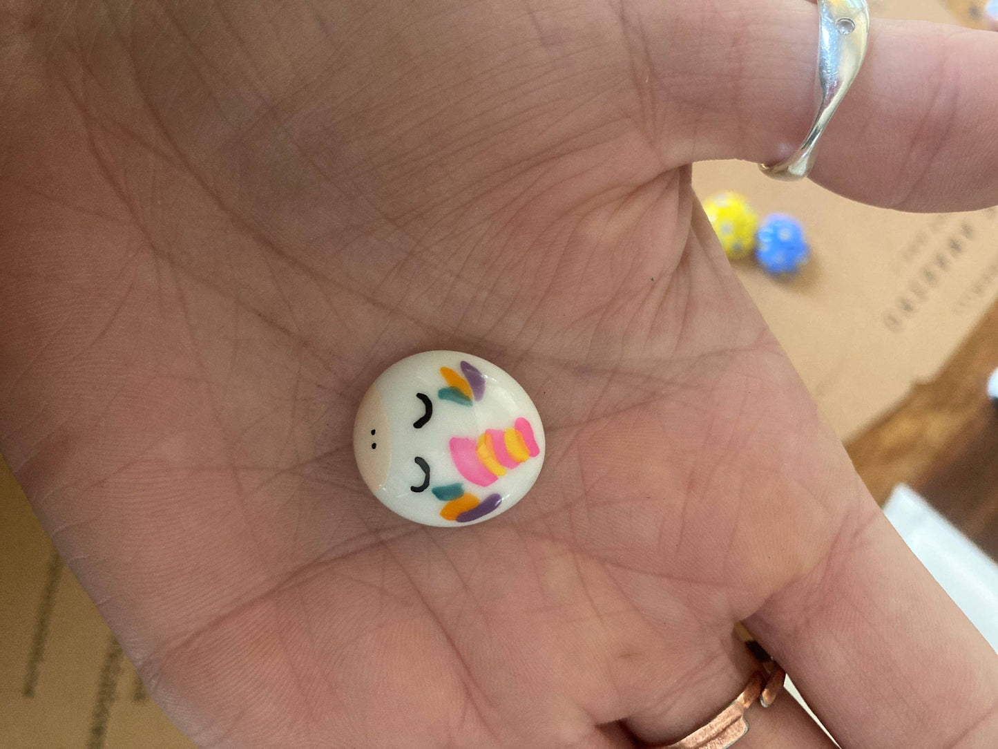 Colorful button with smiley face design held in a hand
