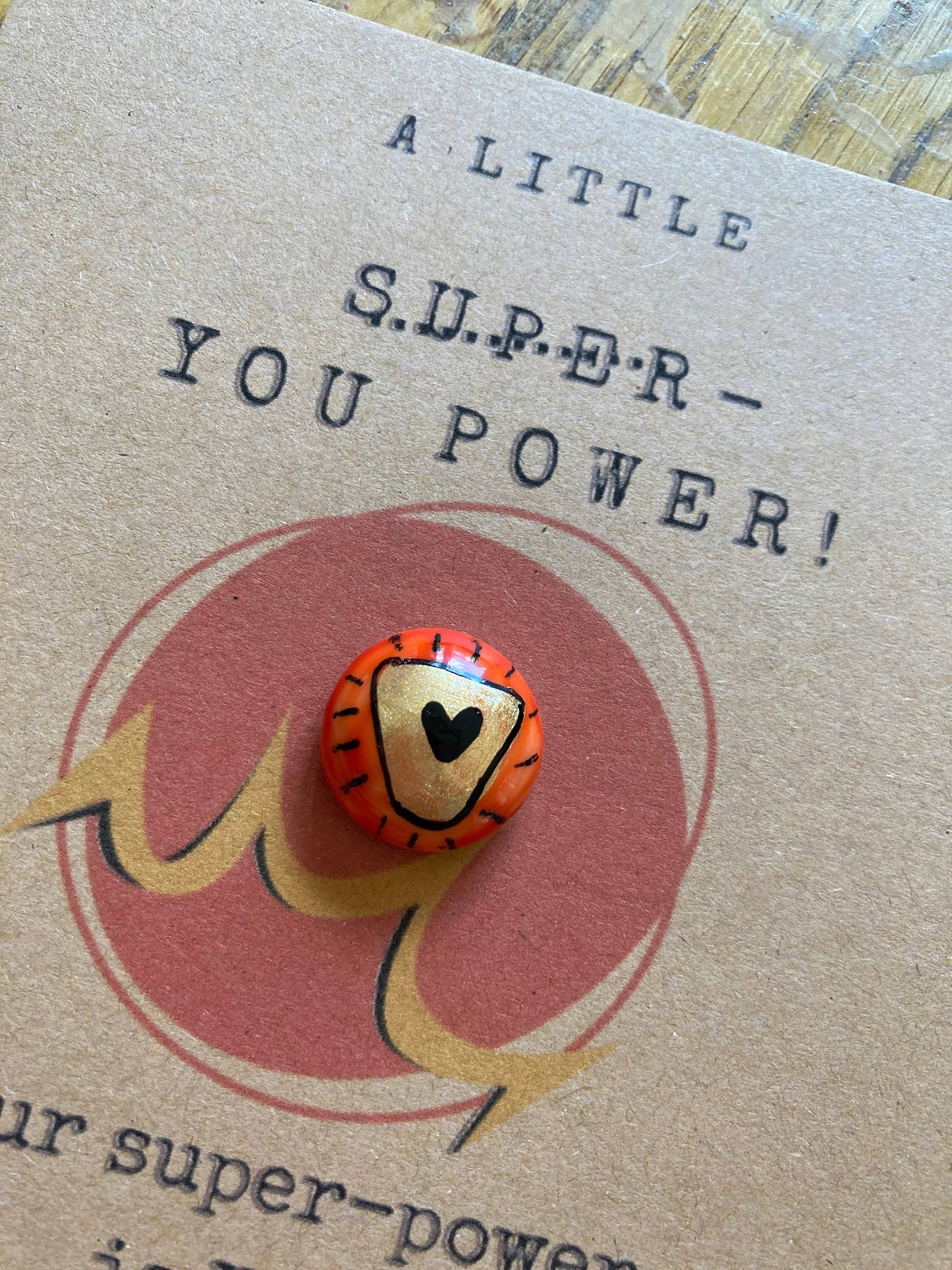 Card with a button featuring a heart design and text on a textured surface