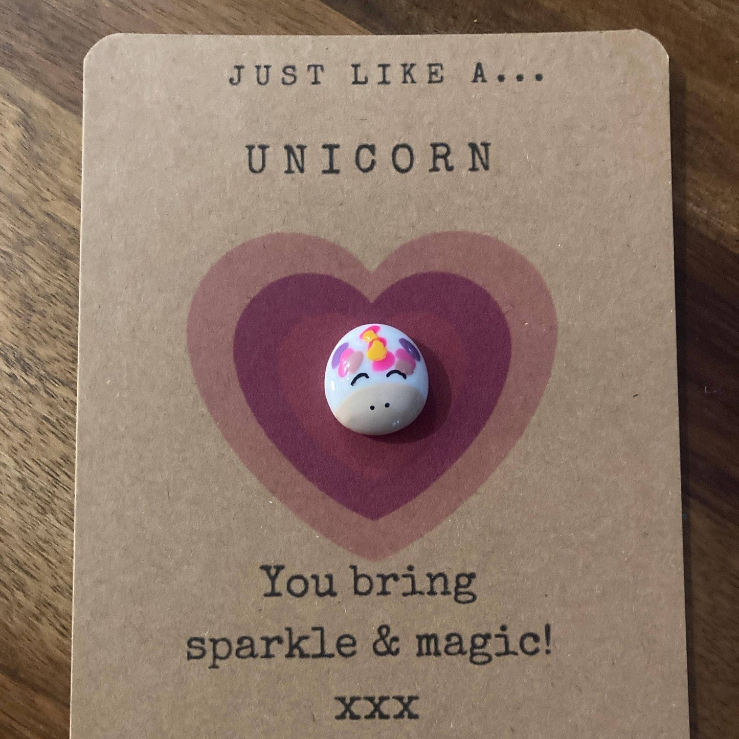 charm with unicorn design on a heart-shaped card with text