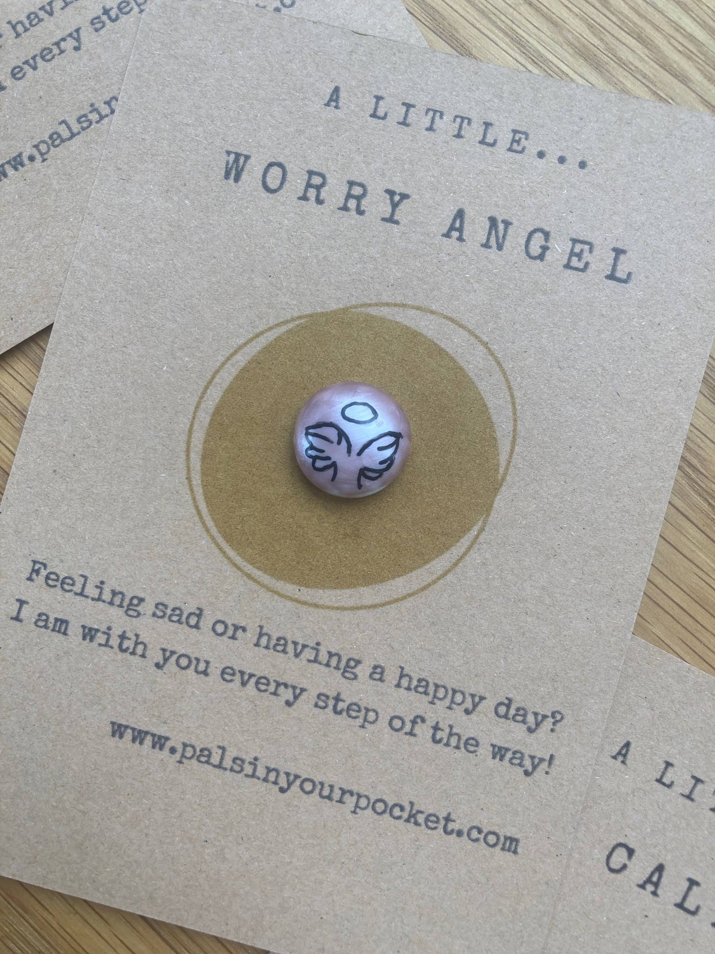 Pink worry charm on a card with text