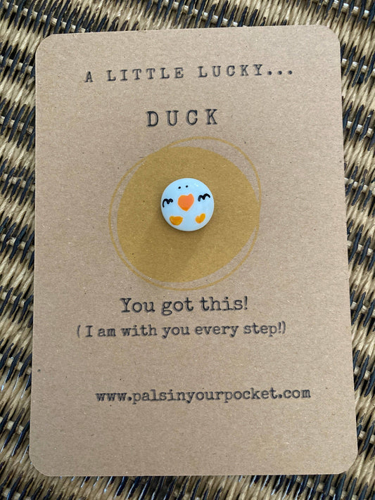 Pebble with duck design on a brown card with text