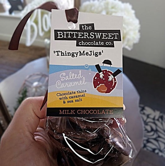 Hand holding a package of 'ThingyMeJigs' salted caramel chocolate from the Bittersweet Chocolate Co.