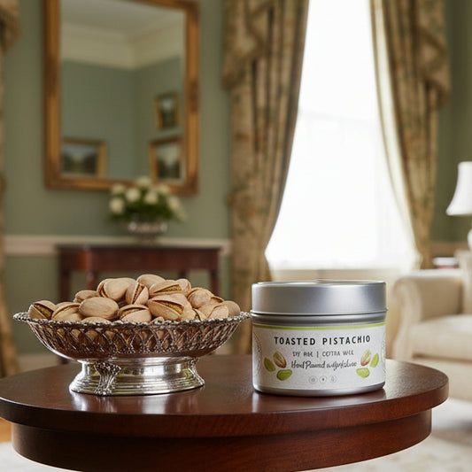 Candle tin labeled 'Toasted Pistachio' on regency table