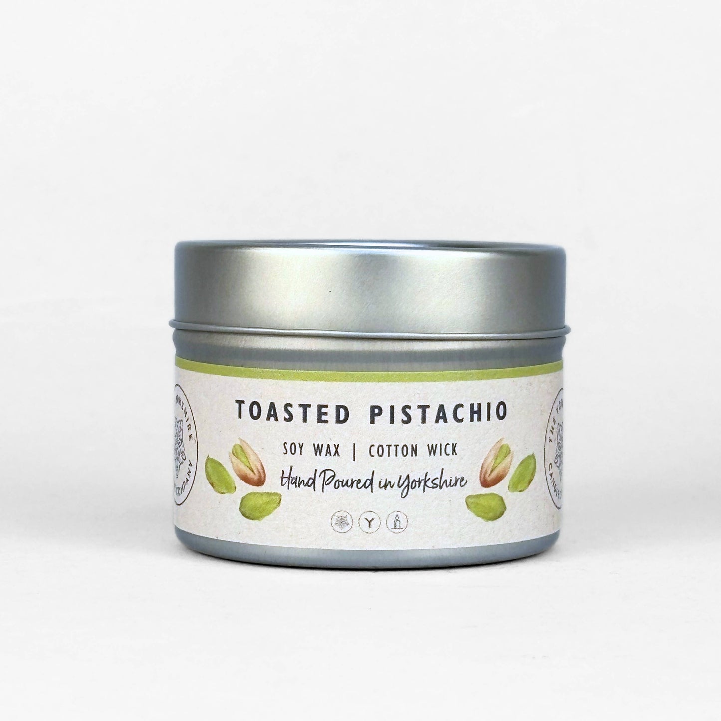 Candle tin labeled 'Toasted Pistachio' on a white background