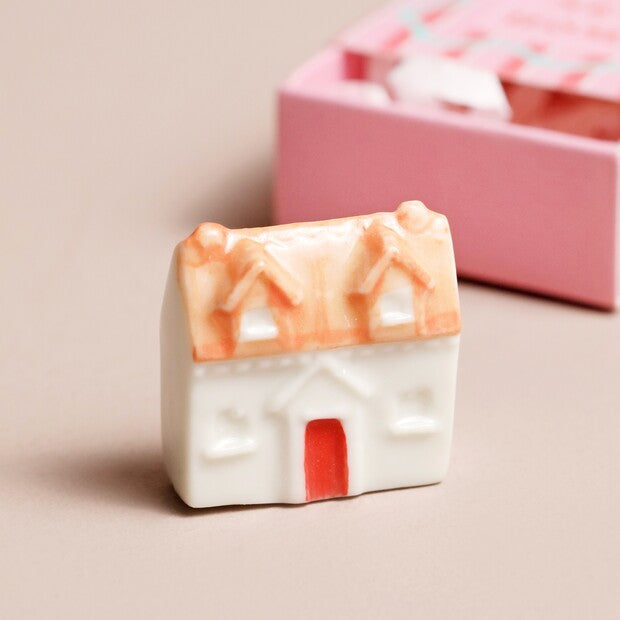 Decorative soap shaped like a house with a red door on a beige background