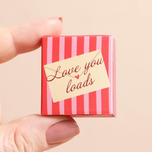 Small red and pink striped matchbox with a 'Love you loads' message on a beige background