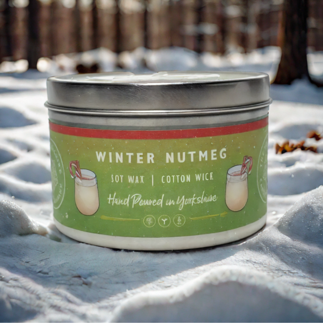 Candle tin labeled 'Winter Nutmeg' in the snow