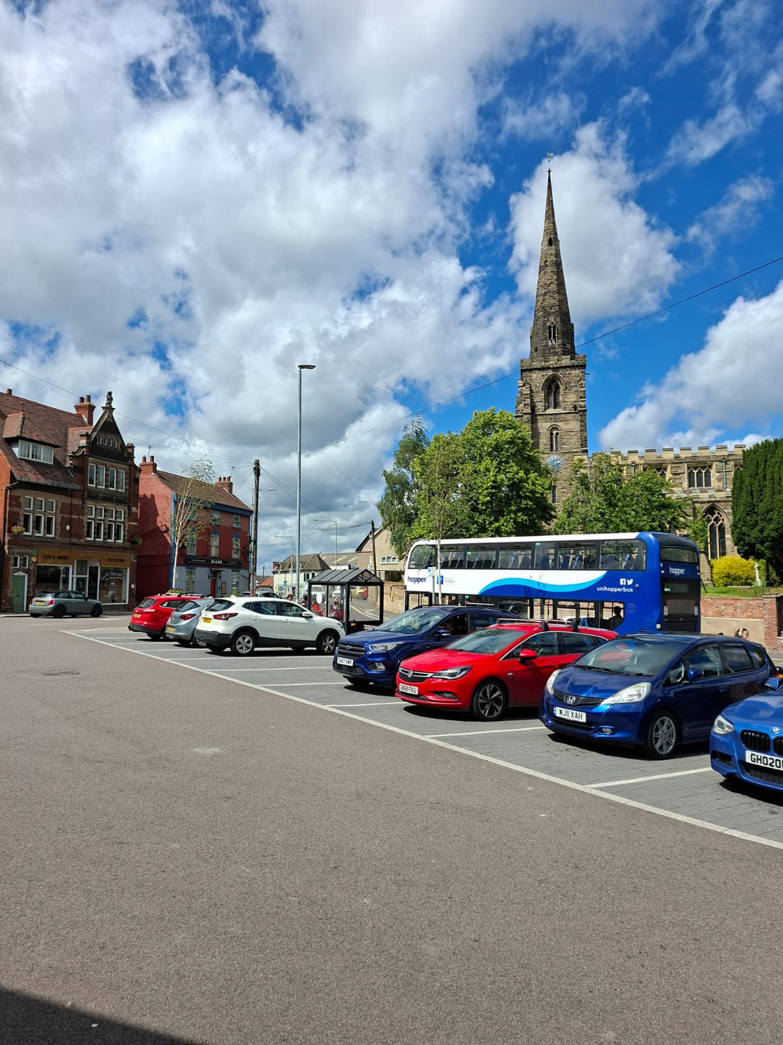 Kegworth Market Place on a sunny market day, with artisan stalls and shoppers enjoying the village atmosphere