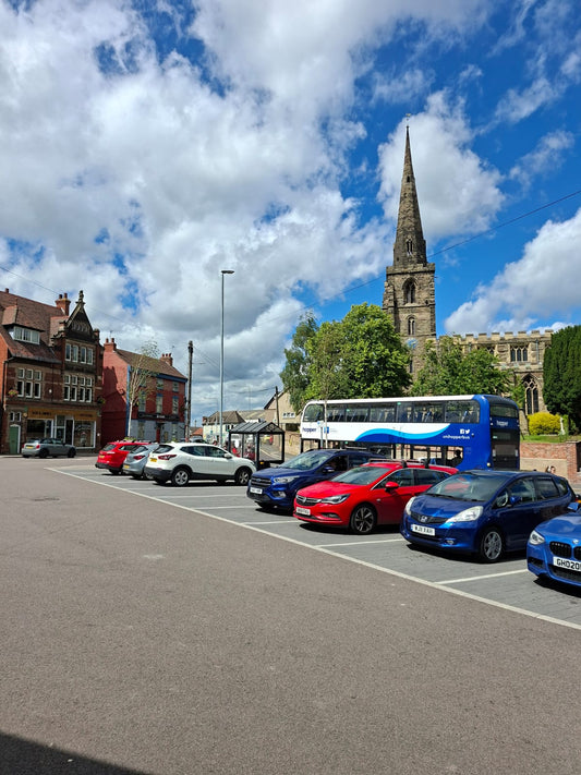 Kegworth Market Place on a sunny market day, with artisan stalls and shoppers enjoying the village atmosphere