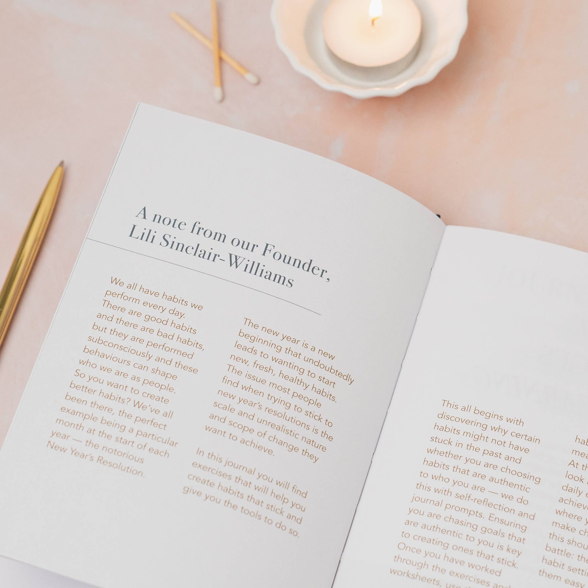 Open book with text on a soft pink background with candles and matches.