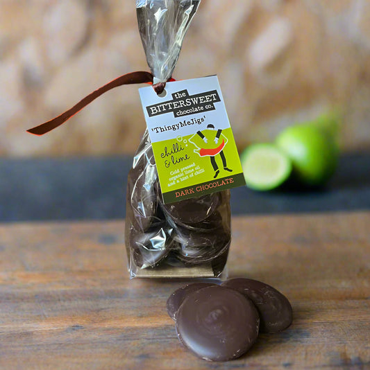 Packaged dark chocolate bites with a label on a wooden surface