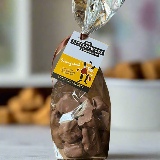 Bag of milk chocolate candies with a 'Bittersweet Chocolates' label on a wooden surface.