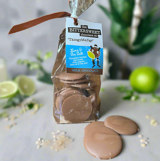 Packaged chocolate discs with a visible label on a wooden surface