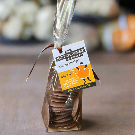 Packaged chocolate buttons with a label on a wooden surface