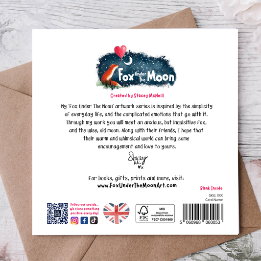Back of a card with 'Fox Under The Moon' branding and text on a wooden surface