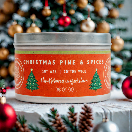 Candle tin labeled 'Christmas Pine & Spices' with a Christmas tree in the background