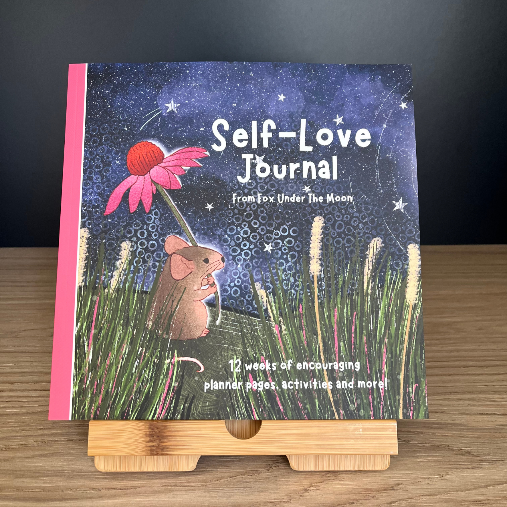Self-Love Journal titled 'From Fox Under the Moon' on a wooden stand with a dark background