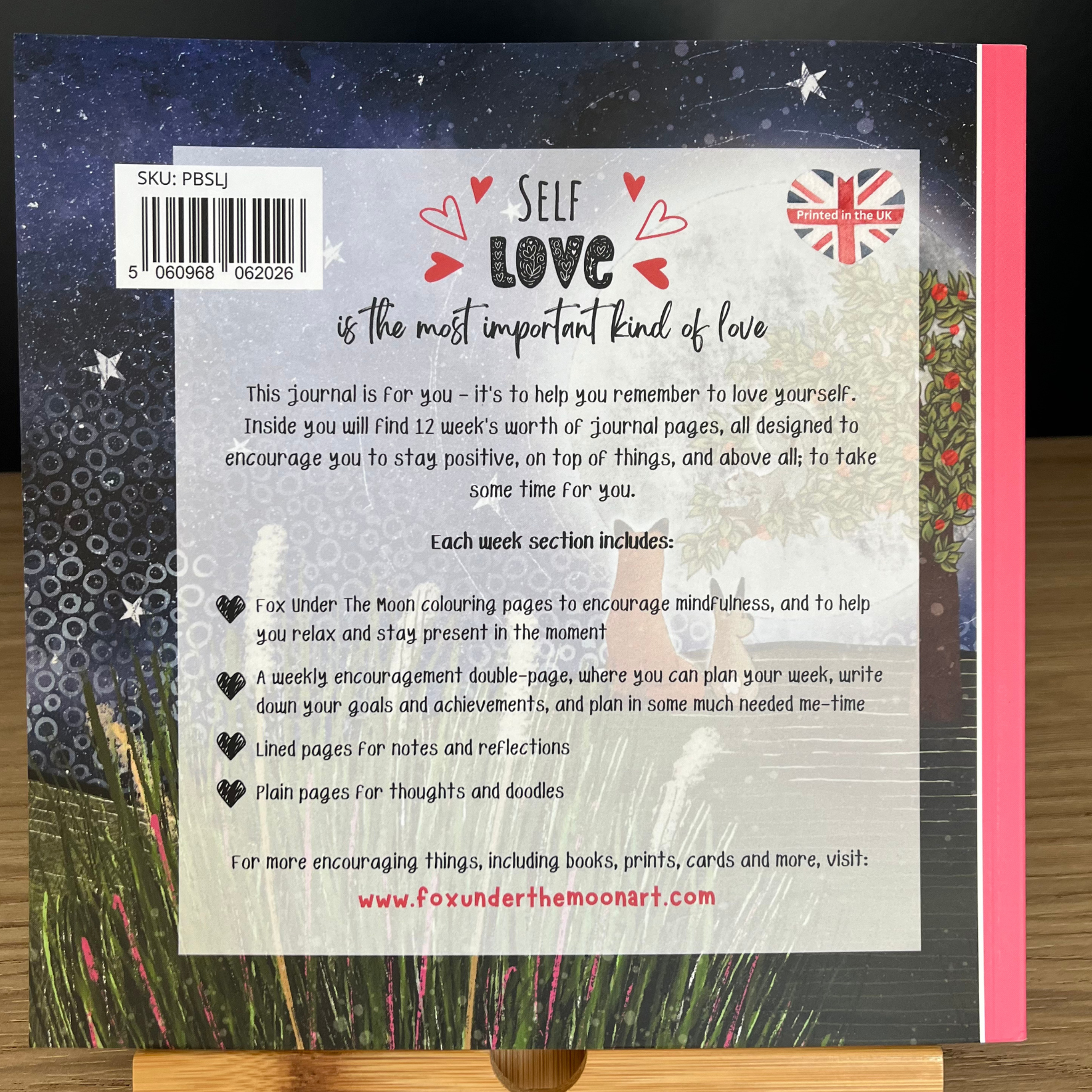 Back cover of a journal with text and design elements on a wooden surface