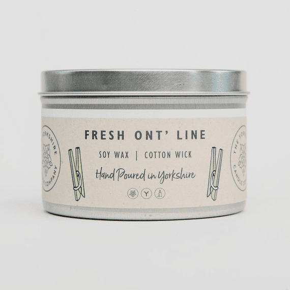Candle in a metal tin with a label on a white background