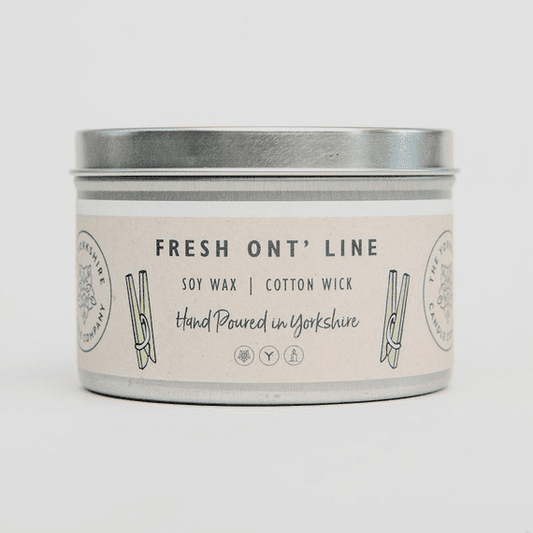Candle in a metal tin with a label on a white background