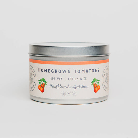 Candle tin labeled 'Homegrown Tomatoes' on a light gray background