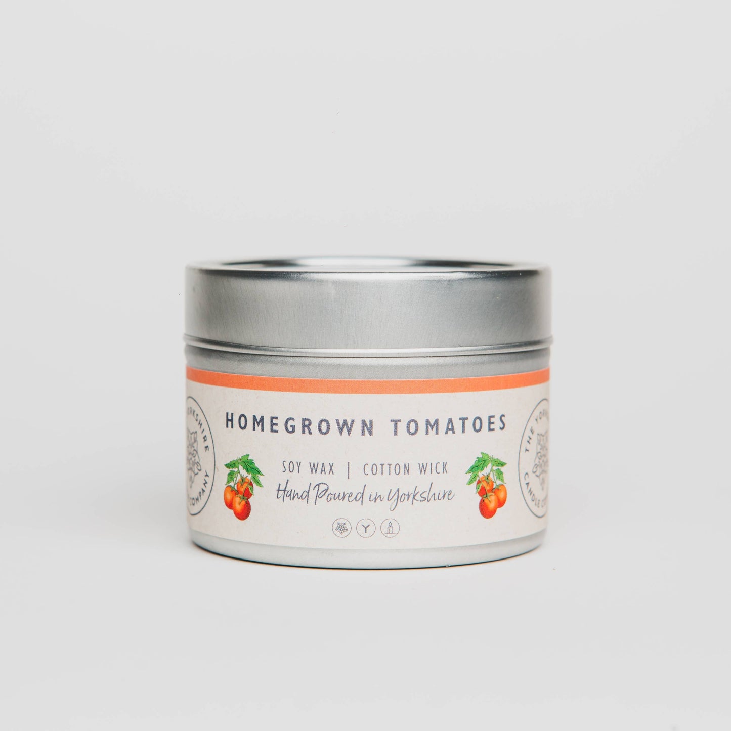 Candle tin labeled 'Homegrown Tomatoes' on a light gray background