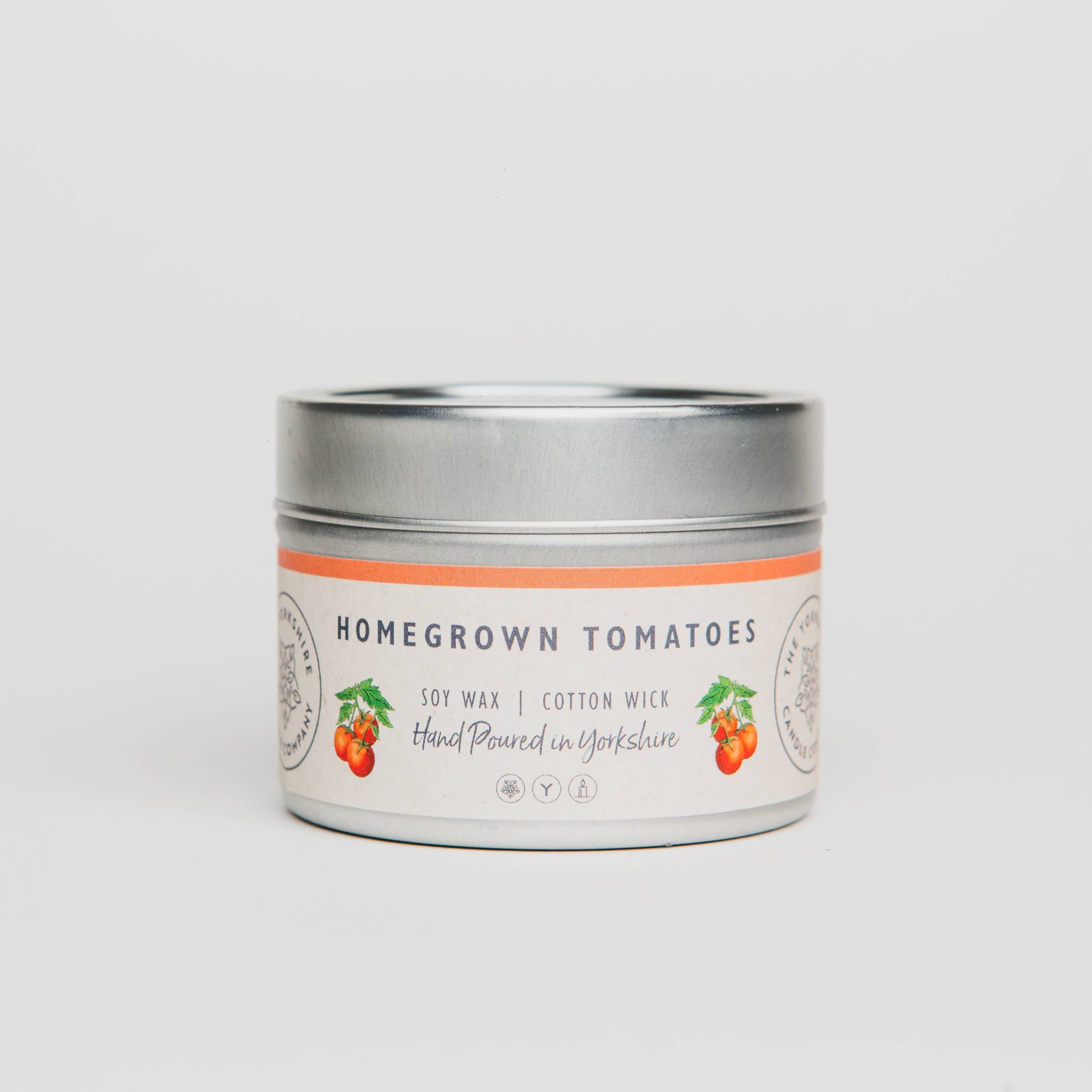 Candle tin labeled 'Homegrown Tomatoes' on a light gray background