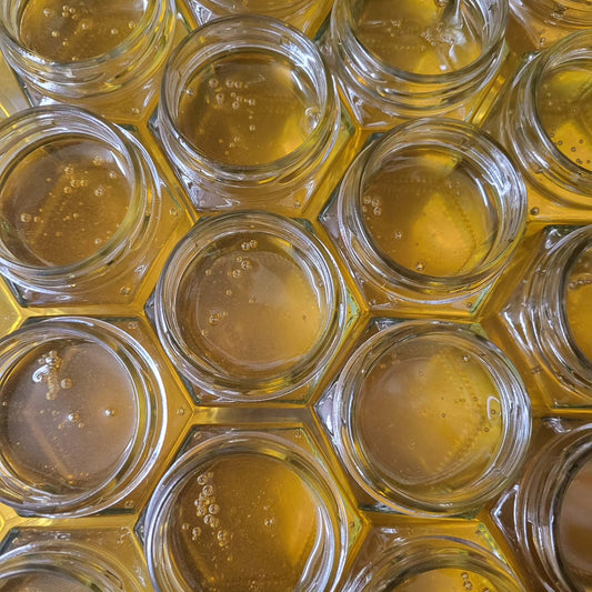 Close-up of hexagonal glass containers filled with a yellowish liquid.