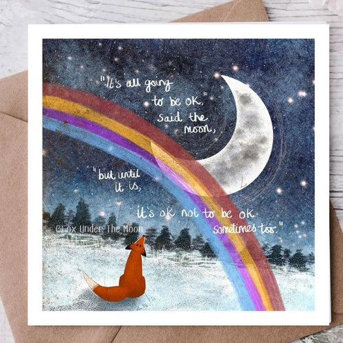 Card with a fox under a rainbow and moon, featuring motivational text on a wooden surface.