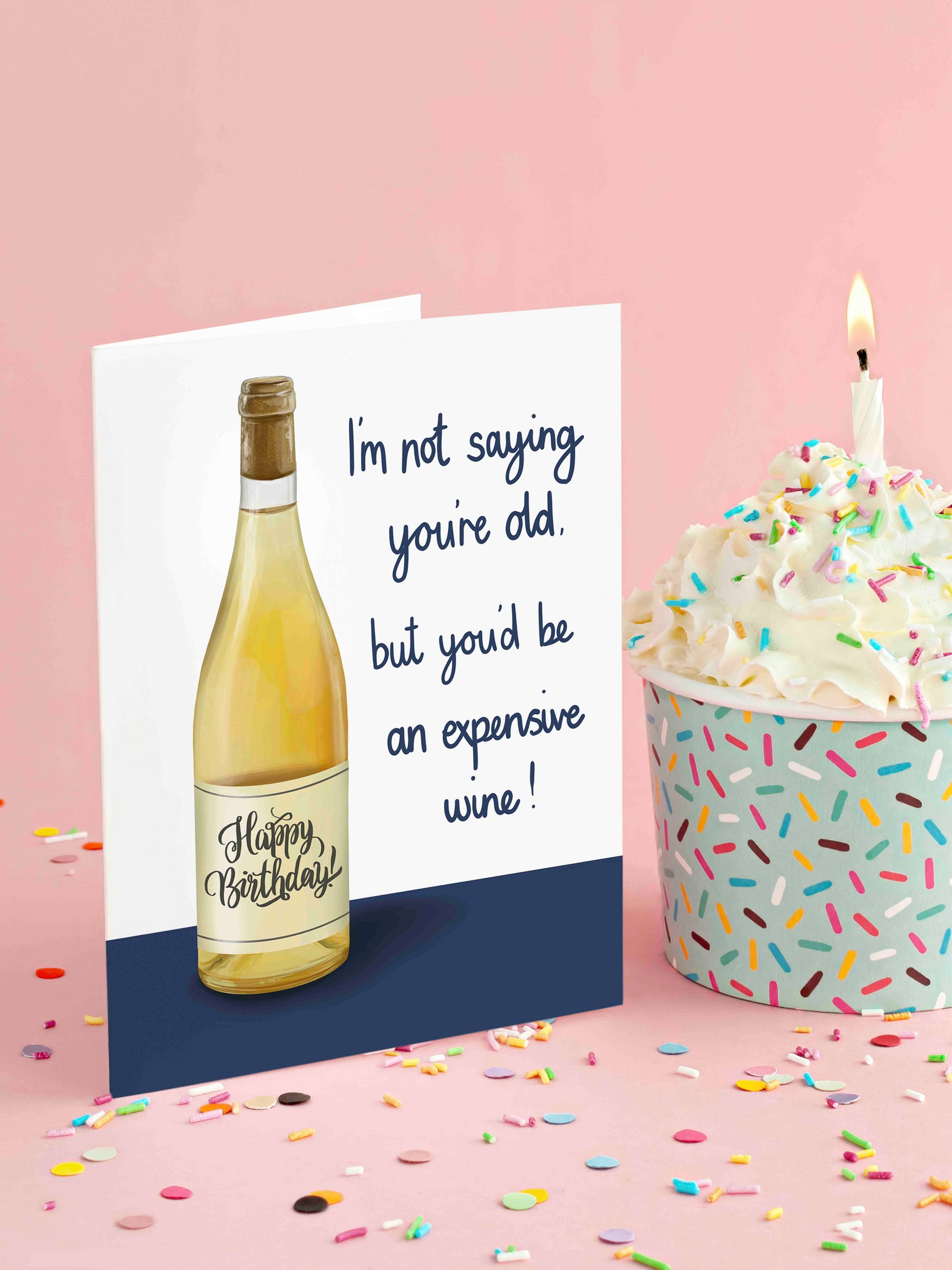 Birthday card with wine bottle design and birthday cake on a pink background