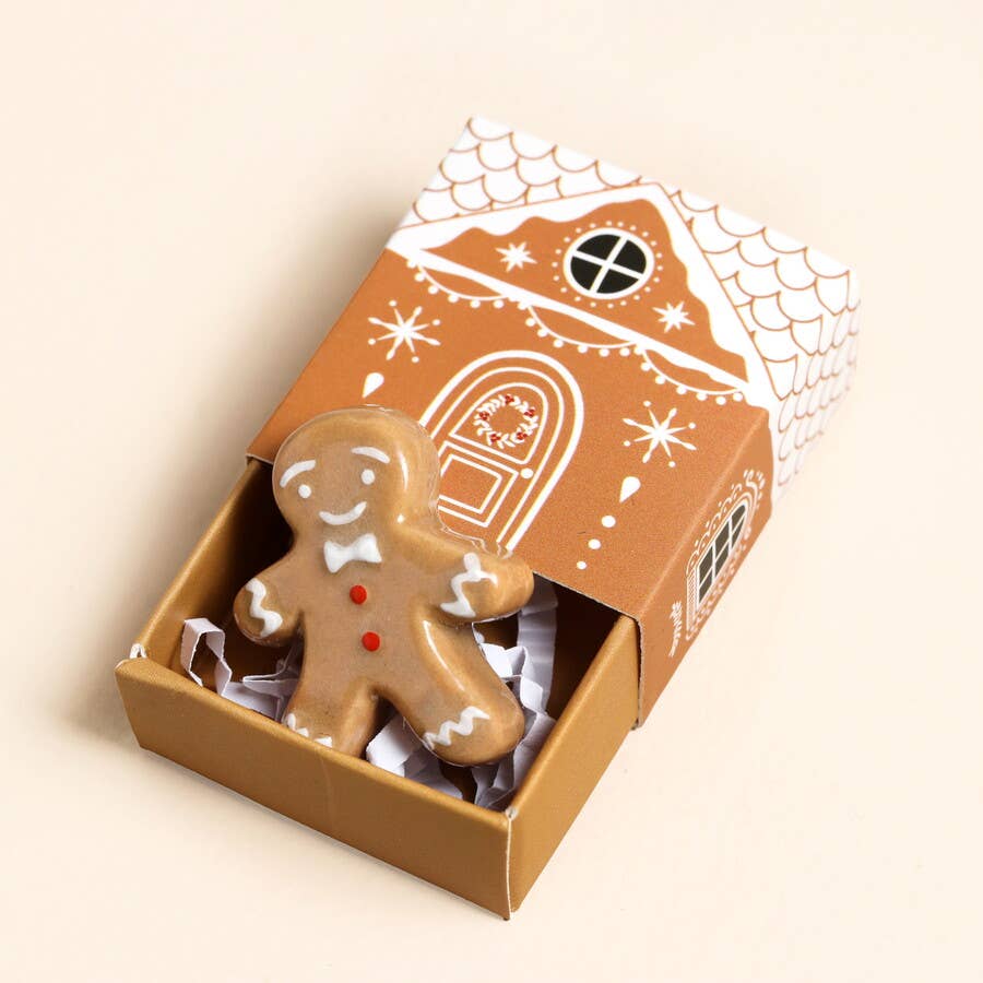 Gingerbread man token in a decorative box with a house design on a beige background