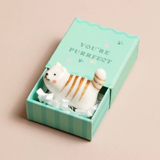 Small cat figurine in a green box with 'You're Purrfect' text on a beige background