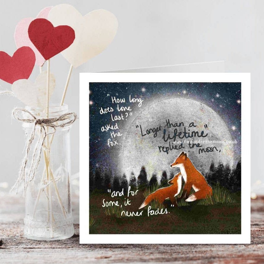 Decorative setup with a jar of hearts, a fox illustration, and romantic text on a wooden surface.