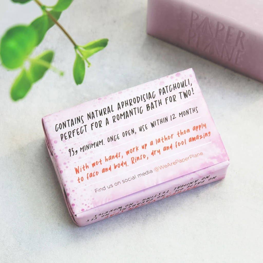 Pink soap bar with text on a light surface, featuring the brand 'Paper Plane'.
