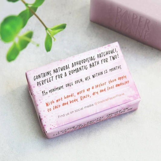 Pink soap bar with text on a light surface, featuring the brand 'Paper Plane'.